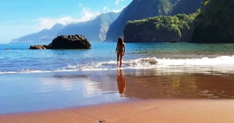 praia seixal best beaches & natural swimming pools on madeira island a woman standing on a rocky beach