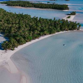 Aerial view of tropical islands with palm trees and turquoise water.