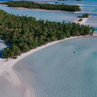 Aerial view of tropical islands with palm trees and turquoise water.