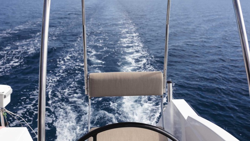 View from a boat's helm with ocean and horizon in sight.
